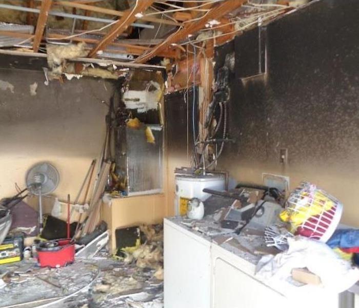 Utility room with extreme fire damage around furnace and appliances