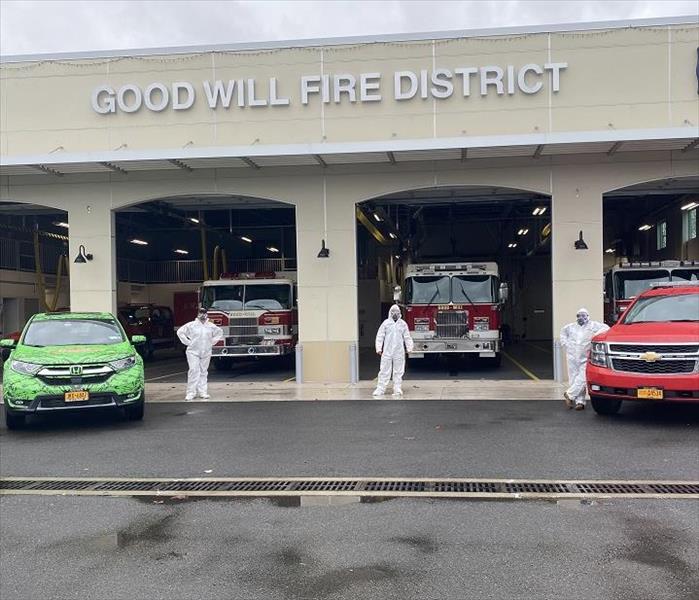 Outside view of fire station; SERVPRO technicians in PPE