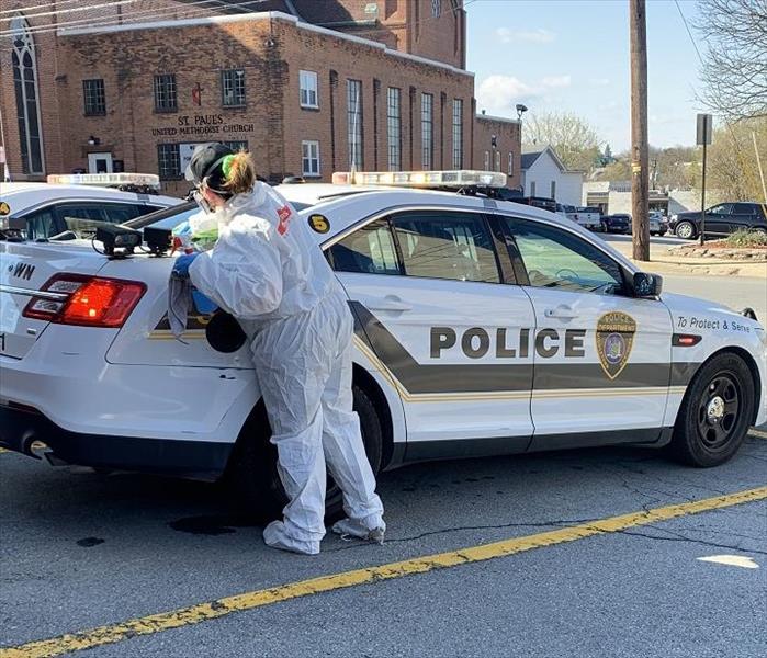 SERVPRO tech cleaning police vehicle