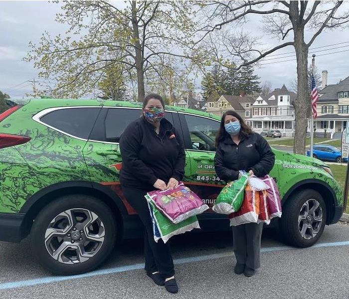 SERVPRO employees standing beside SERVPRO vehicle