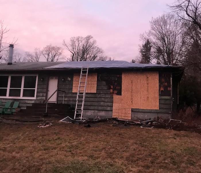 House with fire damage and boarded up windows