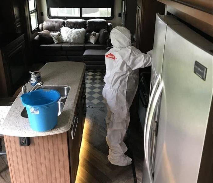 white-suited tech, spraying inside of RV