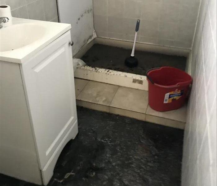 bathroom with sewer water and debris
